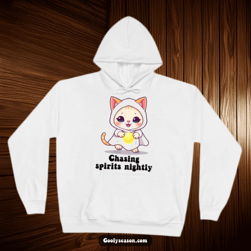 Funny cat in a ghost costume, chasing a glowing orb, printed on a warm, soft hoodie.