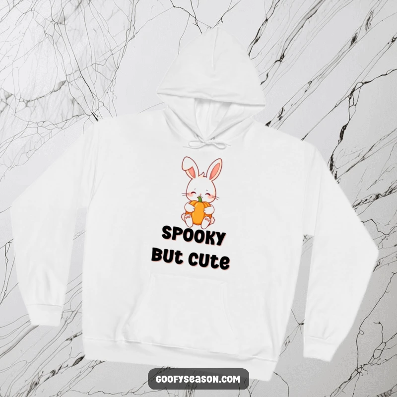 Funny Kawaii bunny shyly holding a pumpkin, perfect for staying warm this autumn on a hooded sweatshirt.