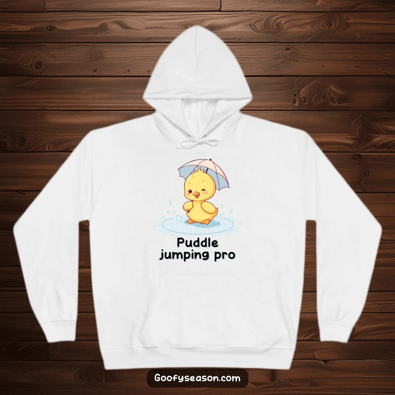 Funny hoodie depicting a happy duckling wearing a small umbrella, splashing playfully in a rain puddle.