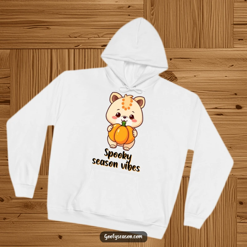 Funny kawaii animal character proudly holding a pumpkin, radiating warmth and happiness in this cozy hoodie design.