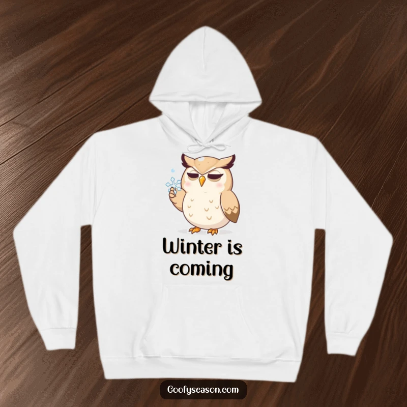 Funny hoodie showcasing a determined owl character intensely focused on catching a delicate snowflake with its beak, ideal for winter comfort.