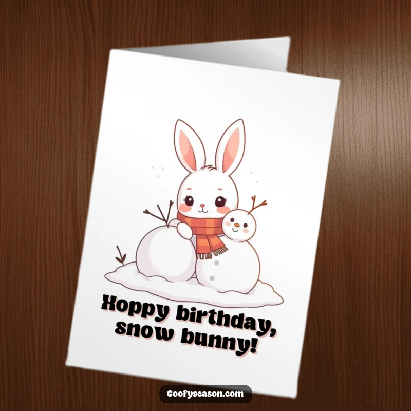 Funny Free Printable Birthday Card: A curious bunny in a scarf happily builds a snowman, looking proud of its work.