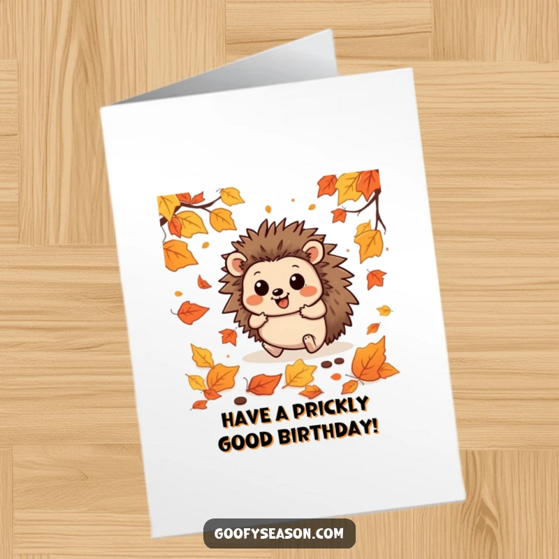 Funny free printable birthday card depicting a happy hedgehog comically tripping and tumbling amongst a huge pile of colorful autumn leaves.