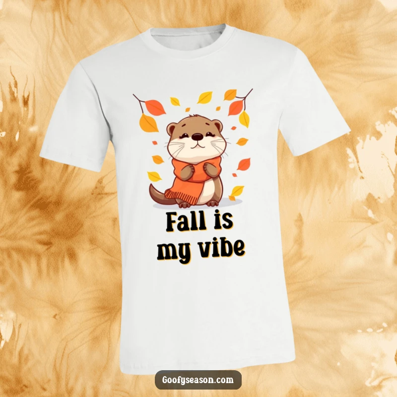 Funny T-Shirt: A curious otter wearing a warm scarf watches falling autumn leaves.
