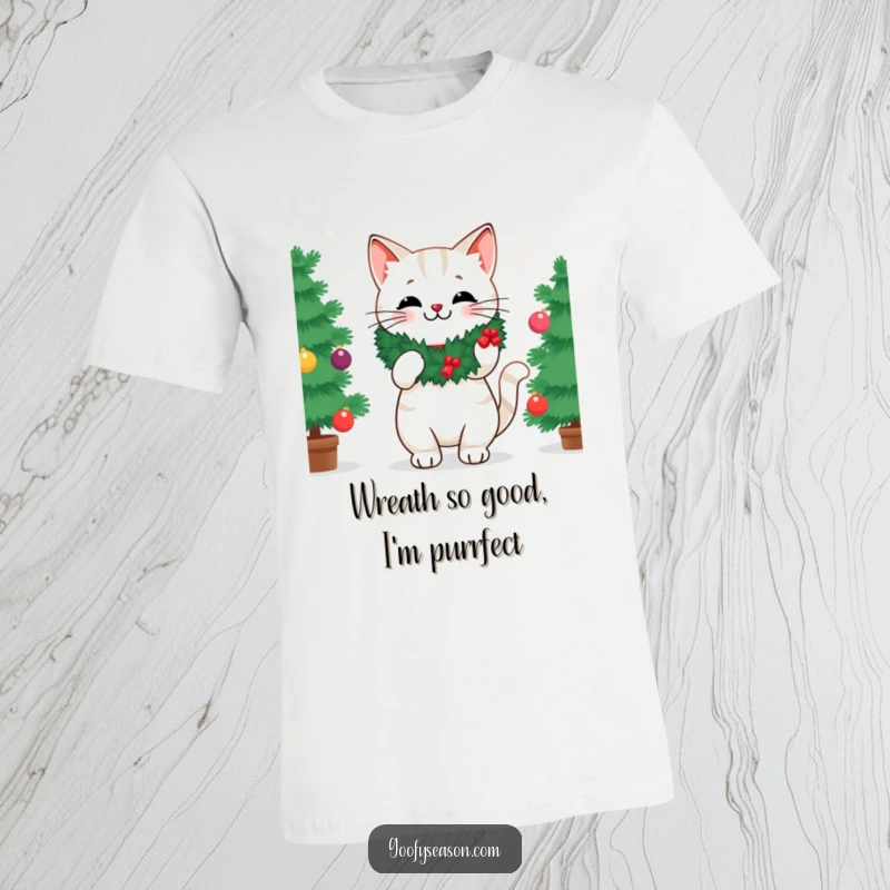 Funny t-shirt showcasing a cheerful cat with a wreath, energetically decorating a Christmas tree with baubles and lights.