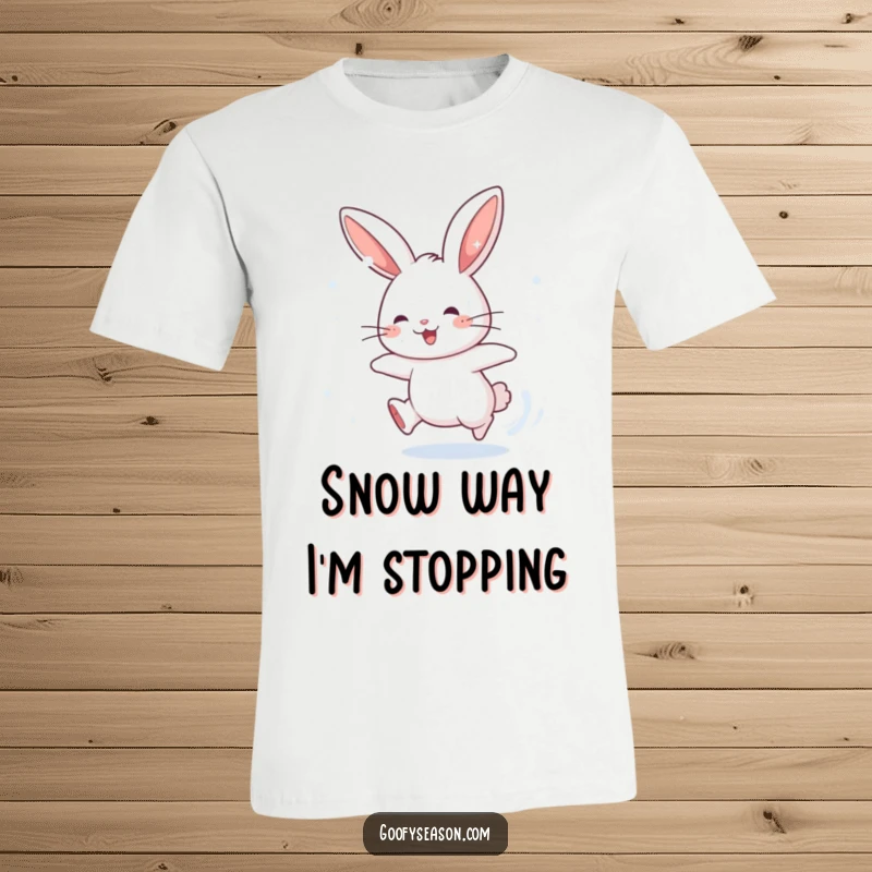 Funny t-shirt depicting an energetic rabbit character leaping after falling snowflakes, radiating playful winter joy and humor.