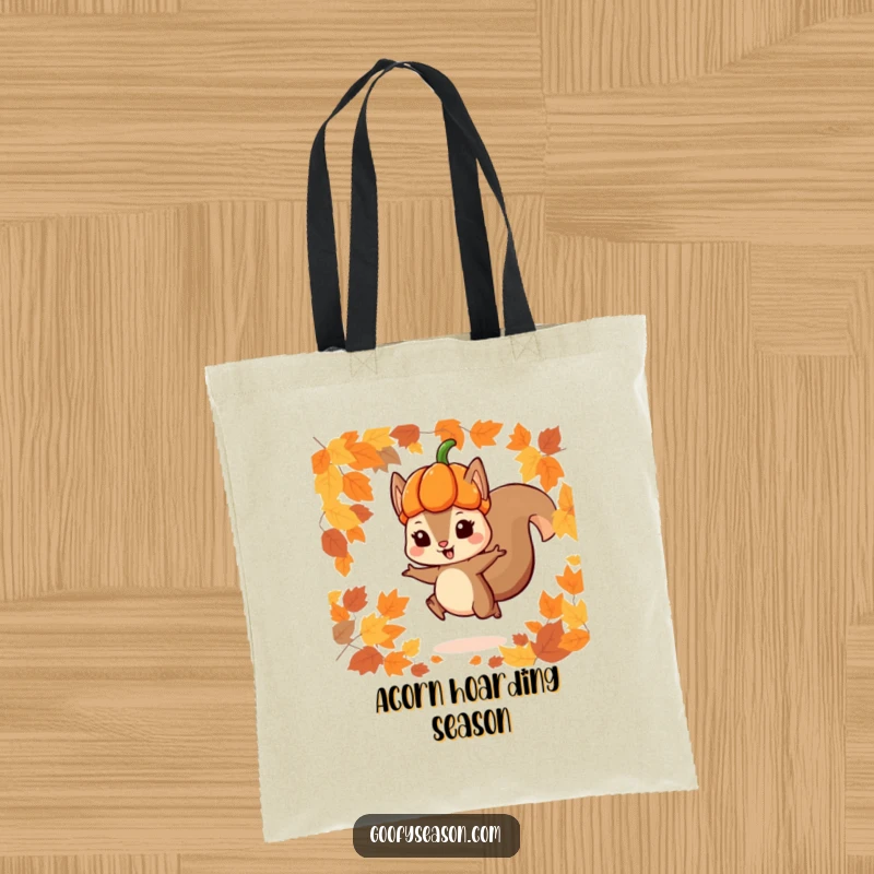 Funny tote bag featuring a playful squirrel in a pumpkin hat jumping through autumn leaves, ideal for carrying essentials with seasonal flair.