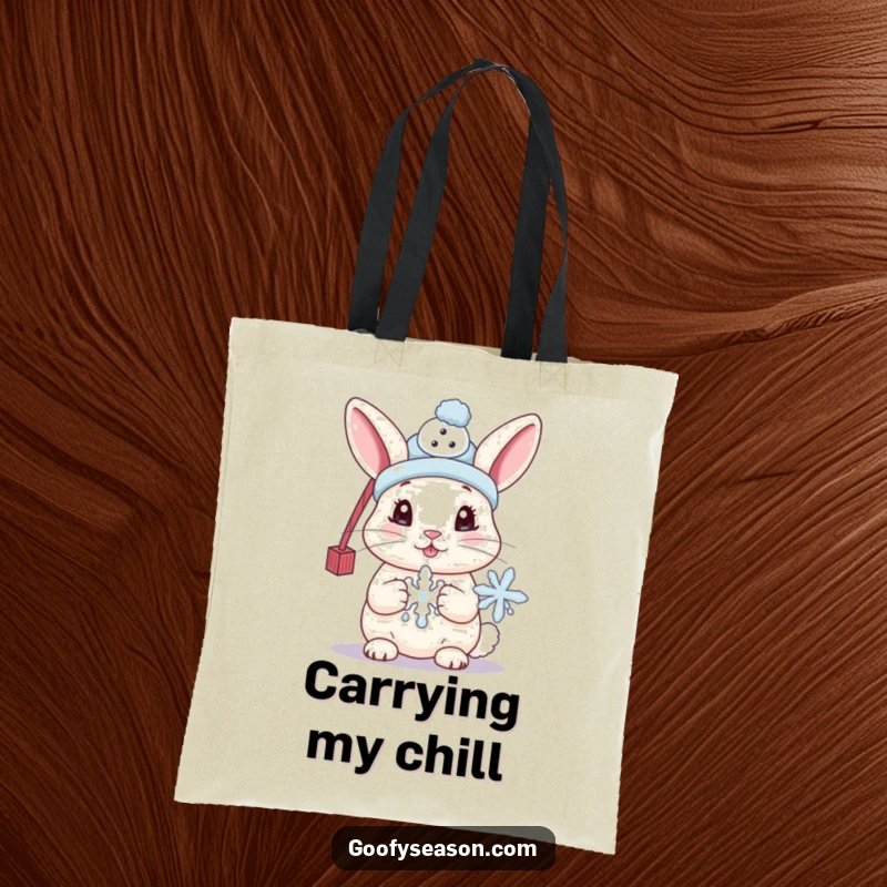 Funny tote bag featuring a cute bunny wearing a tiny snowman hat and holding a melting snowflake, perfect for carrying winter items.